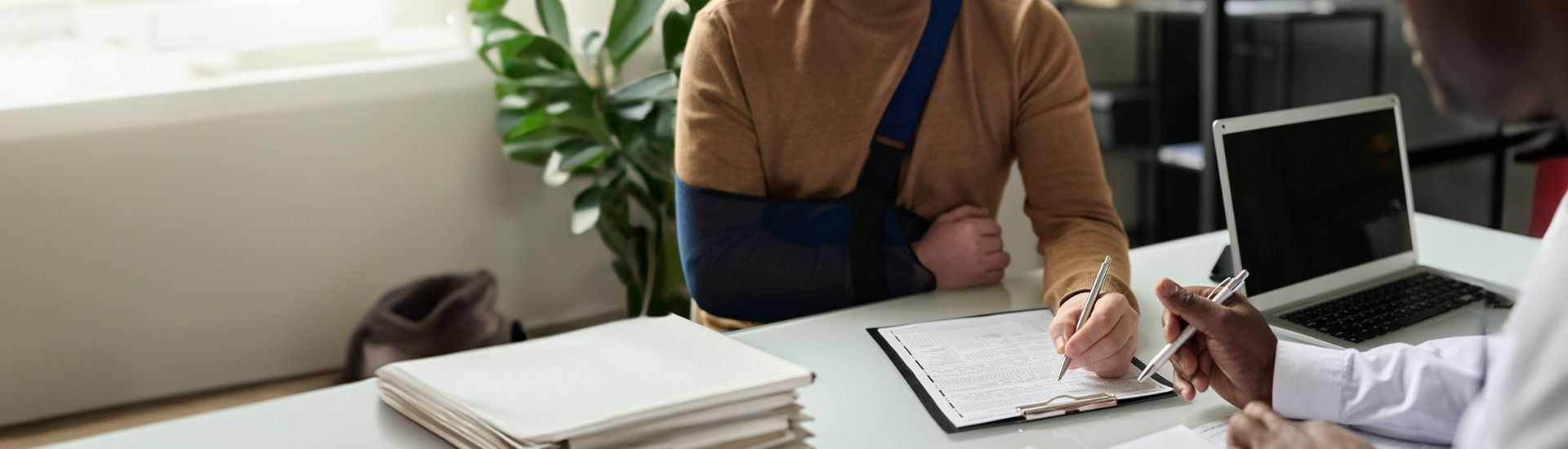 Eine verletzte Person unterschreibt ein Papier.