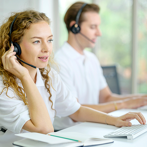 Eine Frau und ein Mann telefonieren mit einem Headset.